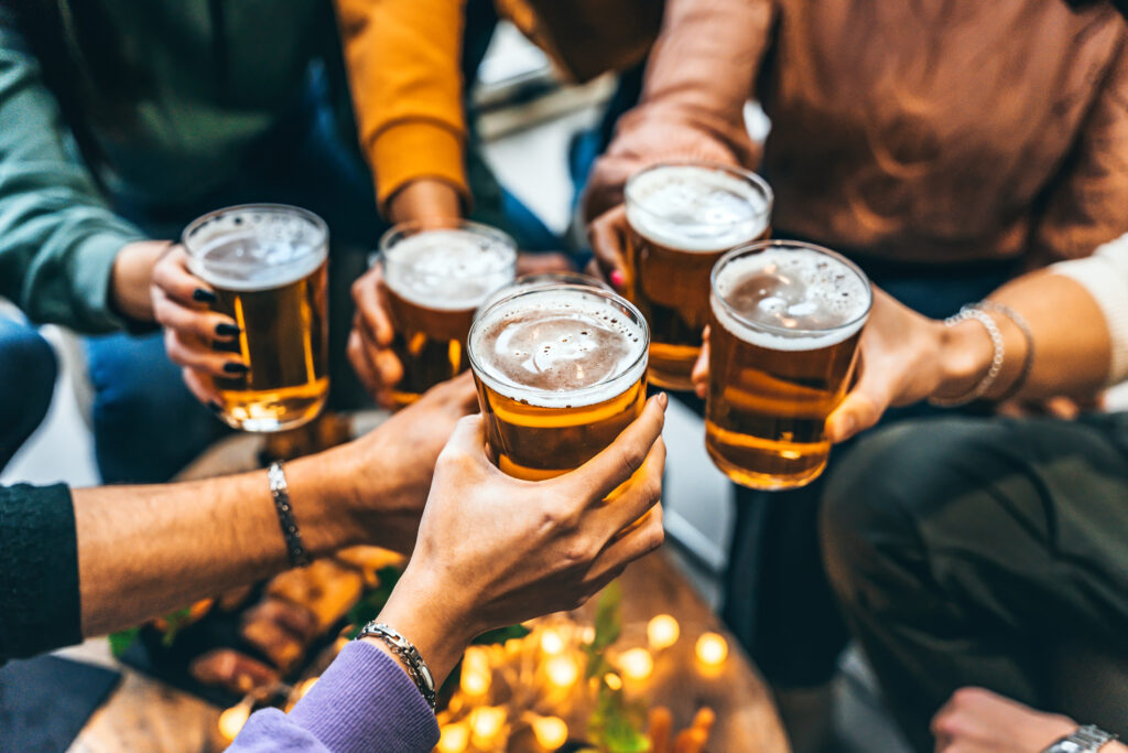 Group of friends drinking and toasting glass of beer at brewery pub